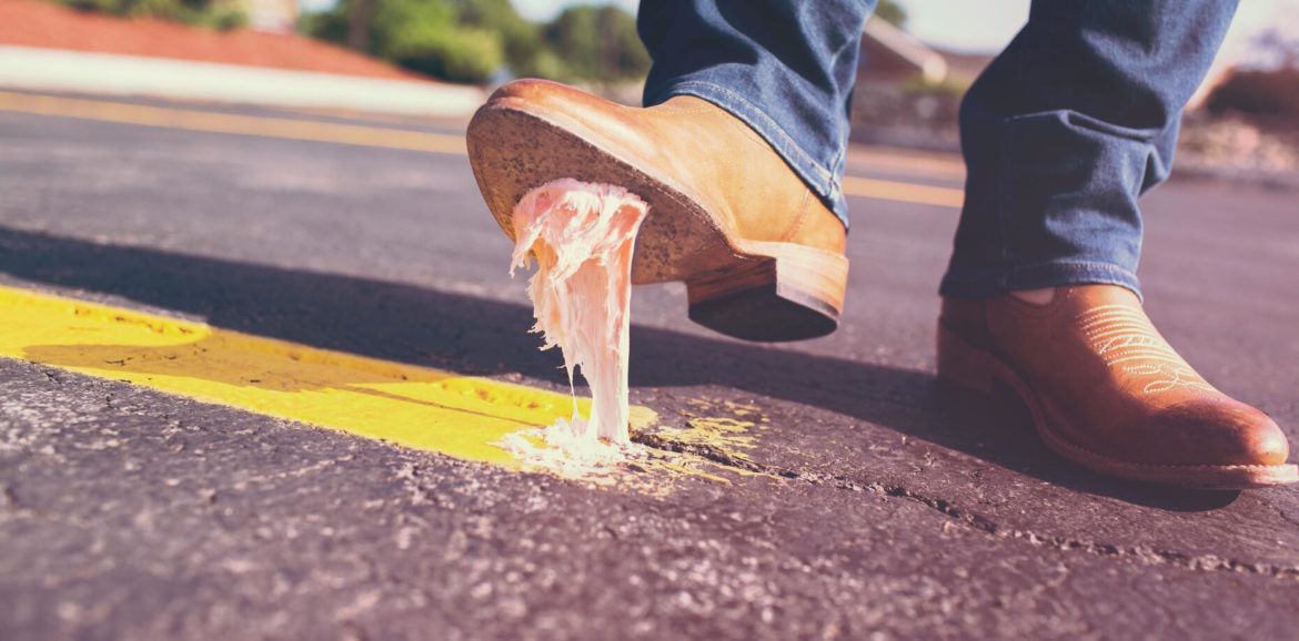 Eine Person läuft auf der Straße und tritt in einen Kaugummi.