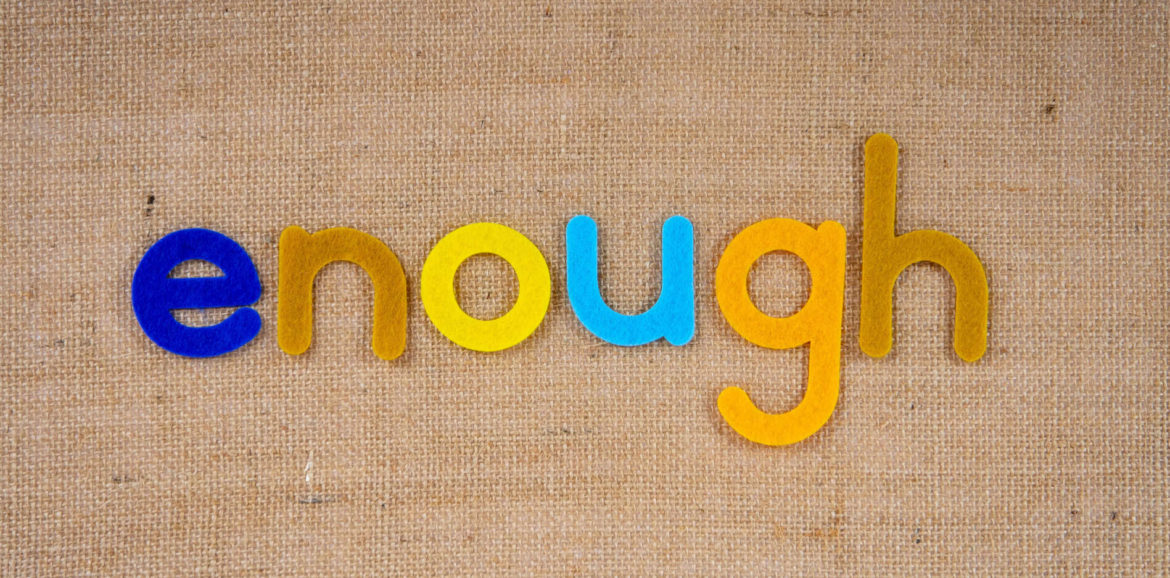 Bunte Stoffbuchstaben, die das Wort "enough" formen auf einem Jutestoff